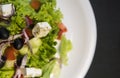 Close up top view on a caesar salad with chicken fillet and parmesan cheese, onion, olives, salad. Royalty Free Stock Photo