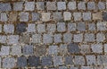 Close up top view of cobblestone with green grass growing and small stones between the cobblestones . Old ancient european town Royalty Free Stock Photo