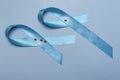 Close up top view of concept for World Diabetes Day 14 November. Blue ribbon with drops of blood on a blue background