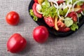 Close-Up top view fresh tomatoes and a part of a plate with vegetarian salad Royalty Free Stock Photo