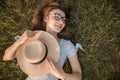 Close-up top view of a girl in the park lying on the green grass. Glasses and hat. Happy youth leisure and recreation Royalty Free Stock Photo