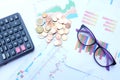 Close up and top view a glasses, money, calculator and chart or graph on office desk table.Finance and business concept. Royalty Free Stock Photo