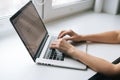 Close-up top view hands of business woman typing on laptop keyboard sitting at window sill at home, working from office. Royalty Free Stock Photo