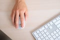 Close-up top view hands of unrecognizable business man using wireless computer mouse sitting at desk with white modern Royalty Free Stock Photo