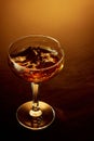Close up top view of high glass of whiskey, rum, brandy or gin over warm gradient background.
