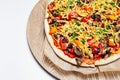 Close-up top view of homemade vegan pizza on wooden plate on white background. Royalty Free Stock Photo