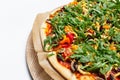 Close-up top view of homemade vegan pizza on wooden plate on white background. Royalty Free Stock Photo