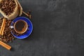 Close-up and top view of hot black coffee in blue coffee cup and roasted Thai coffee beans on wooden background. Royalty Free Stock Photo