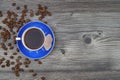 Close-up and top view of hot black coffee in blue coffee cup and roasted Thai coffee beans on wooden background Royalty Free Stock Photo