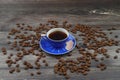 Close-up and top view of hot black coffee in blue coffee cup and roasted Thai coffee beans on wooden background Royalty Free Stock Photo