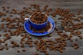 Close-up and top view of hot black coffee in blue coffee cup and roasted Thai coffee beans on wooden background Royalty Free Stock Photo