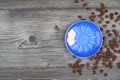 Close-up and top view of hot black coffee in blue coffee cup and roasted Thai coffee beans on wooden background Royalty Free Stock Photo