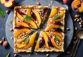 A close-up top view of a peach fruit tart with sliced peaches and hazelnuts on top Royalty Free Stock Photo