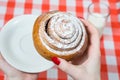 Close up, top view photo of tasty sugary cinnamon roll in woman` Royalty Free Stock Photo