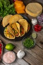 Close-up top view of plate with mexican tacos on rustic wooden table with ingredients for cooking background. Concept of Royalty Free Stock Photo