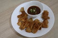 Close-up, top view, pork belly marinated in fish sauce, battered and fried with sauce placed on a plate.