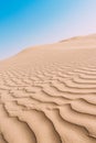 Close up top view of sand dune surface with undulated wave patterns former by wind