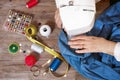 Close-up top view, of senior woman hands seamstress sewing jeans on electrical sewing machine.