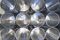 Top view of several rows of metal containers with holeson a shelf in a store or on a production line in a factory