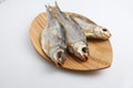 Close up top view shot of three Russian dried salted vobla Caspian Roach fish on a wooden plate on a white background