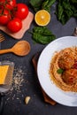 Close-up, top view, spaghetti with grated cheese and meatballs on a plate, wooden table. Royalty Free Stock Photo