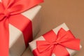 Close-up brown paper gift box red bow ribbon brown background. concept for happy love gift Royalty Free Stock Photo