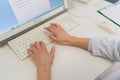 Close-up top view hands of unrecognizable female doctor in white coat working and typing on laptop computer keyboard at Royalty Free Stock Photo