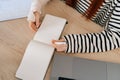 Close-up top view of unrecognizable injured young woman with broken hand wrapped in white gypsum bandage writing on Royalty Free Stock Photo