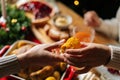 Close-up top view of unrecognizable young woman and man passing delicious boiled corn sitting at festive Christmas table Royalty Free Stock Photo