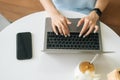 Close-up top view of unrecognizable young woman wearing smart watch typing on laptop keyboard sitting at table in cafe Royalty Free Stock Photo
