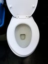 Close up and Top view white flushing toilet, water closet or lavatory with black floor Royalty Free Stock Photo