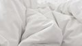 Close up top view of white pillow on bed and with wrinkle messy blanket in bedroom Royalty Free Stock Photo