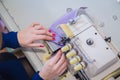 Close up top view - woman hands using overlock sewing machine Royalty Free Stock Photo