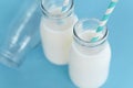 Close up topview bottle of fresh milk with straw on light blue background, selective focus