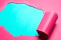 Close-up of torn pink paper with space for text of cyan background. Royalty Free Stock Photo
