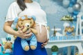 Close-up of torso of young pregnant model standing in baby shower