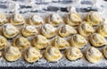 Close up of tortellini sprinkled with flour on a dark board.