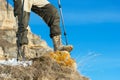 Close-up of a tourist`s foot in trekking boots with sticks for Nordic walking standing on a rock stone in the mountains Royalty Free Stock Photo