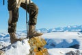 Close-up of a tourist`s foot in trekking boots with sticks for Nordic walking standing on a rock stone in the mountains Royalty Free Stock Photo