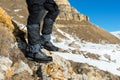 Close-up of a tourist`s foot in trekking boots with sticks for Nordic walking standing on a rock stone in the mountains Royalty Free Stock Photo