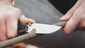 Close-up of the tourist's hands, sharpening a stick with a knife Royalty Free Stock Photo
