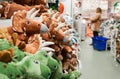 Close-up of toy dinosaurs on store shelves. Blurry shoppers in the background