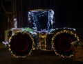 Close up of tractor decorated with festive Christmas garlands.