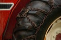 A close-up of a tractor door and tire with a chain Royalty Free Stock Photo