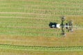 Close up of a tractor turning cut grass to dry for hay. Rural landscape. An new tractor presses hay into a roll. Shooting from a d Royalty Free Stock Photo