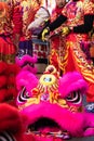 Close-up of a traditional Chinese mask and participants in the Chinese New Year parade behind, dressed in traditional costumes and