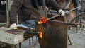 Close up of traditional glass blower forming a beautiful piece of glass in a workshop. Royalty Free Stock Photo