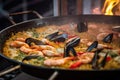 Close-up of a traditional Paella pan with sizzling hot rice, seafood, vegetables and aromatic herbs Royalty Free Stock Photo