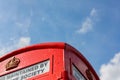 Close up of a traditional red British telephone box against a clear blue summer sky Royalty Free Stock Photo