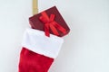 Close up of traditional red and white plush Christmas stocking stuffed with red wrapped present Royalty Free Stock Photo